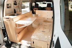 the interior of an empty van with its doors open and shelves stacked on top of each other