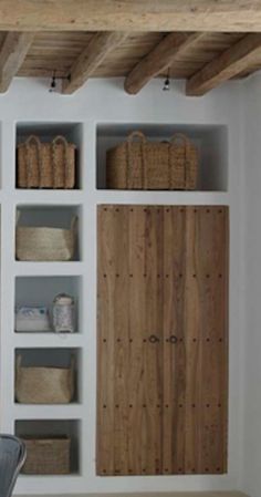 an empty room with shelves and baskets on the wall