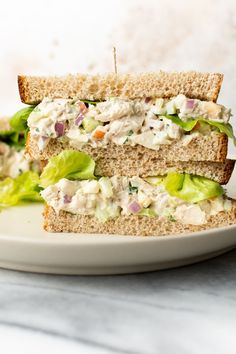 a chicken salad sandwich cut in half on a plate