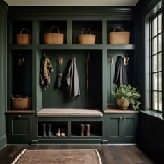 an entryway with green painted walls and wooden flooring, lined with hanging baskets