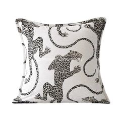 a white and black pillow with leopards on it