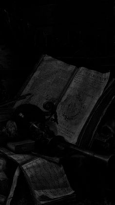 an old book and some other items are on the table in this black and white photo