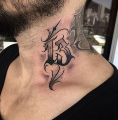 a man with a neck tattoo that has the letter f on it and is looking to his left