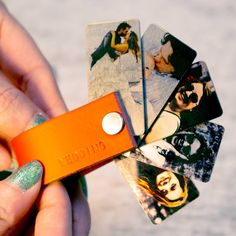 a person holding an orange card with pictures on it and a lighter in their hand