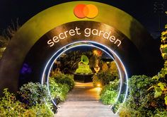 the secret garden entrance is lit up at night