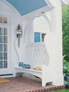 an image of a porch with blue and white accents on the front door, windows and bench