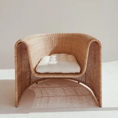 a wicker chair with a white pillow on it