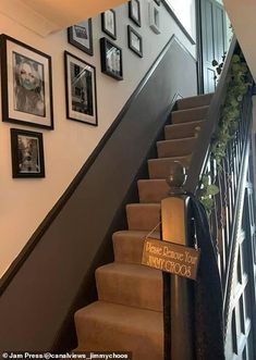 a staircase with pictures on the wall next to it