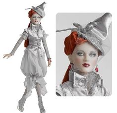 a doll with red hair wearing a silver dress and hat