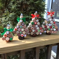 three wine cork christmas trees sitting on top of a wooden table next to a window