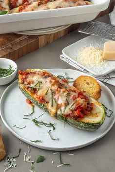 an eggplant stuffed with meat and cheese on a white plate next to bread