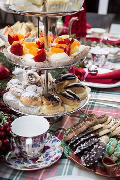 three tiered trays filled with pastries and desserts on top of a table