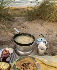 a bowl of soup and some food on the beach