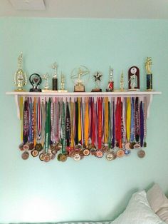 there are many medals on the shelf above the bed and in front of the headboard