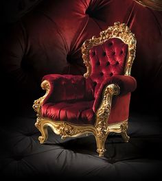 an ornately decorated red chair with gold trim