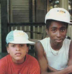 three young men sitting next to each other in front of a house with the caption's logo on it