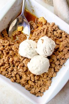 a white dish filled with ice cream and some kind of dessert on top of it