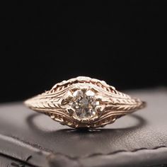 an antique diamond ring sitting on top of a leather case