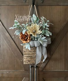 a basket with flowers hanging on the side of a barn door