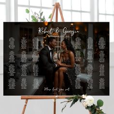 a wedding seating chart on a easel with flowers and greenery in the foreground