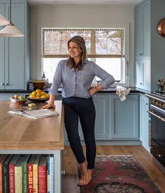 a woman standing in the middle of a kitchen