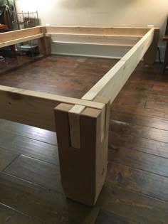 a wooden bed frame sitting on top of a hard wood floor