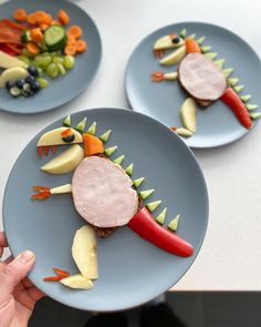 two plates with food on them that look like dinosaurs made out of fruits and vegetables