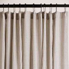 striped curtains hanging on a rod in front of a white wall