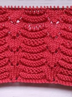 a crocheted red piece of cloth sitting on top of a white table