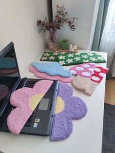 a laptop computer sitting on top of a table covered in bath mitts and rugs