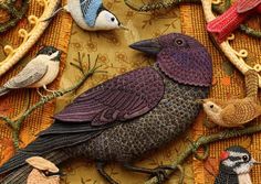 several birds sitting on top of a table covered in beads and yarns next to each other