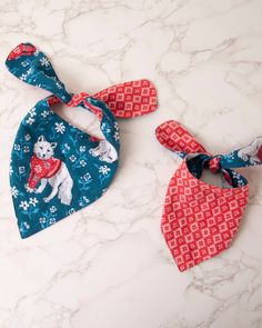 two bandana bibs sitting on top of a marble counter