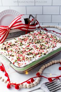 a cake with white frosting and sprinkles on it sitting on a table