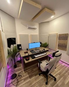 a room with a desk, chair and computer on the table in it is lit up by purple lights