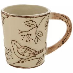 a coffee mug with birds and leaves painted on it