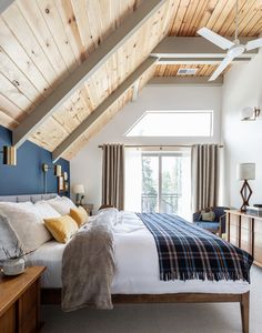 a bedroom with a bed, dressers and windows in it's roof area