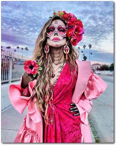 a woman with makeup painted to look like a skeleton wearing flowers in her hair and dress