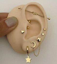 a person holding up a fake ear with gold stars and crescents on the side