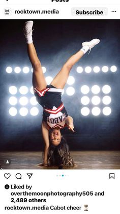 a woman is doing a handstand on the floor in front of some lights