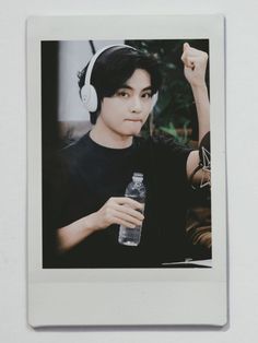 a man with headphones holding a water bottle