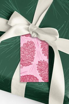 a green gift box wrapped in pink and white ribbon