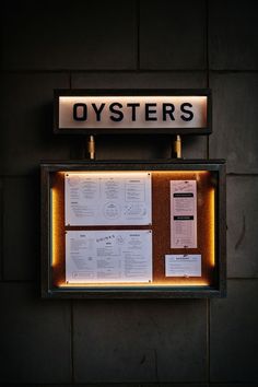 there is a sign that says oysters on the side of a wall with notes attached to it