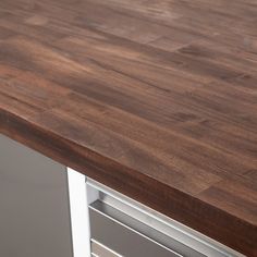 a wooden counter top sitting on top of a metal cabinet