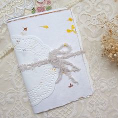 an open book with lace and flowers on it