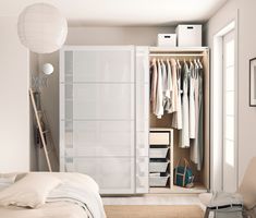 an open closet with clothes hanging on the doors and drawers, along with other items