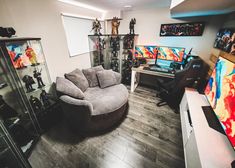 a living room filled with lots of furniture and art on the walls, including a round couch