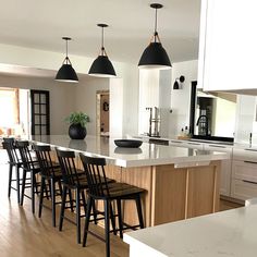 a kitchen filled with lots of counter top space and wooden chairs next to an island