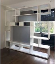 an empty room with white shelving and wood flooring in the middle of it