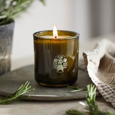 a candle sitting on top of a table next to a potted plant and napkin