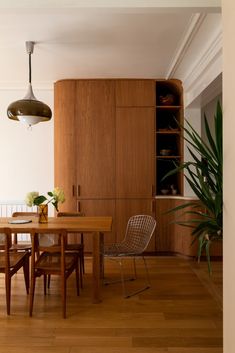 a wooden table and chairs in a room with hard wood flooring on the walls